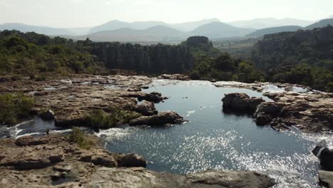 Luftaufnahmen-über-Wasserbecken,-Um-Die-Landschaft-Des-Drakensberg-Waldes-Am-Horizont-Sichtbar-Zu-Machen