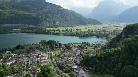 Drone-view-of-the-Walensee-lake-and-housing-near-Weesen,-Switzerland