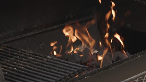Pan-over-to-BBQ-charcoal-briquettes-on-fire-in-slow-motion