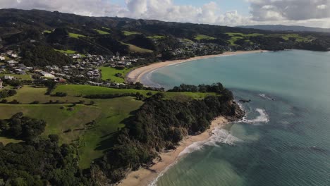 Aerial-view-of-peaceful-Langs-Beach,-small-bay-with-sandy-beach-in-New-Zealand