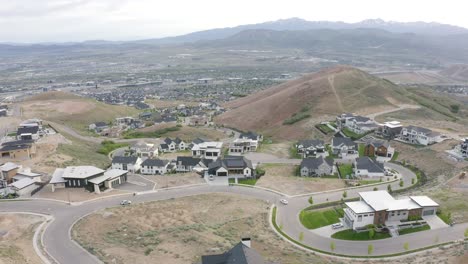 Aerial-shot-of-large-luxury-homes-on-the-hillside-of-Traverse-mountain,-lehi-utah-on-an-overcast-day,-pull-back-shot