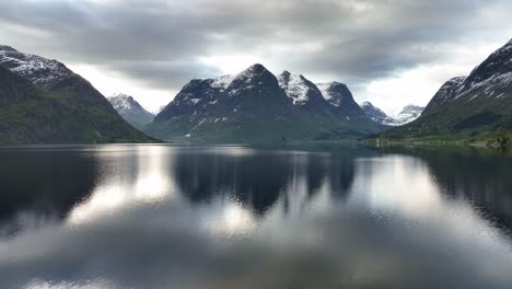 Forward-moving-aerial-above-Oppstrynsvatnet-lake-water-surface---Mountains-Hjellhyrna-and-Grovahyrna-seen-in-middle-of-frame