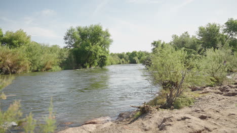 Desert-Sonoran-River-going-through-Arid-Rock-Landscape-with-Green-Trees