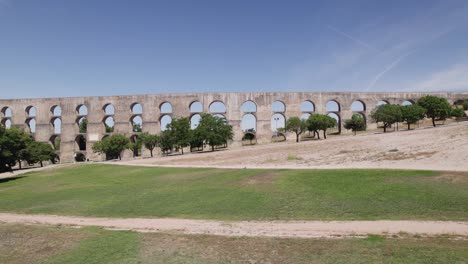 Low-wide-aerial-push-in-of-Amoreira-Aqueduct-in-sunny-Elvas,-Portugal