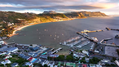 Aerial-cinematic-drone-sunrise-Simon's-Town-naval-boat-marina-fishing-small-quite-city-Cape-Town-South-Africa-early-sunlight-clouds-Table-Mountain-Fish-Hook-Muizenberg-penguins-forward-pan-up-movement