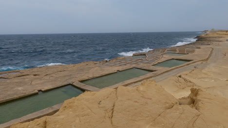 The-beach-of-The-Saltpans-on-Gozo's-northerly-shore,-just-up-from-Marsalforn,-is-a-captivating-feature-and-of-critical-importance-to-Malta
