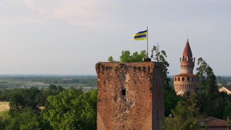 Flag-waving-in-the-wind-on-tower-of-Rivalta-Castle,-Piacenza-in-Italy