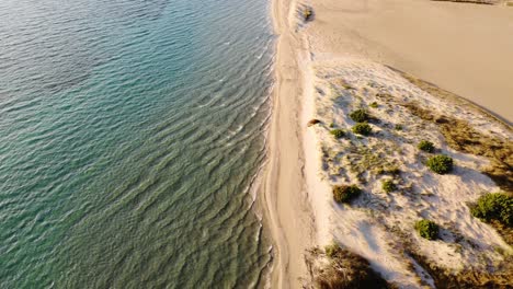 Paradisiac-aerial-view-of-beach-shoreline-with-gentle-waves-splashing,-aerial