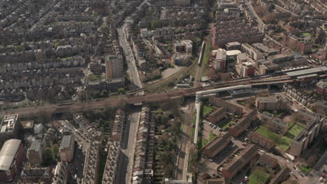Aerial-shot-over-London-overground-train-passing-through-residential-neighbourhoods-in-Hackney