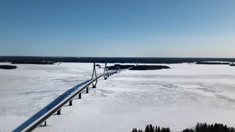 Aerial-ascend-over-Replot-Bridge-during-winter-sunny-day,-Finland
