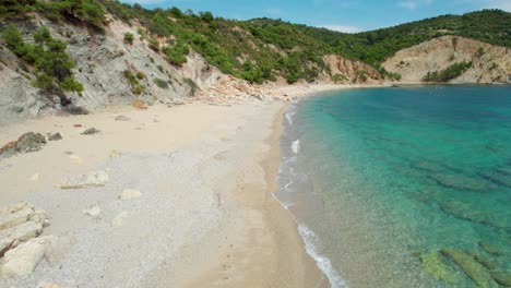 Drone-View,-Isolated-And-Empty-Beach-With-White-Sand,-Turquoise-Water,-Lush-Vegetation-And-Birds-Flying-Around,-Fari-Beach,-Thassos-Island,-Greece,-Europe