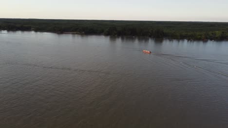 Aerial-view-of-cruising-boat-on-Parana-River-in-Argentina-during-golden-hour