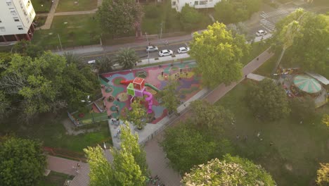 Aerial-birds-eye-shot-of-playground-in-park-with-kids-having-fun-during-sunset-time-in-Buenos-Aires