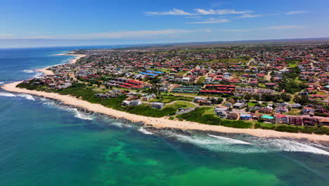 South-Africa-JBAY-Jeffreys-Bay-aerial-drone-town-home-buildings-most-stunning-white-sand-beach-epic-surf-wave-aqua-blue-rugged-reef-coastline-daytime-WSL-Corona-Open-Supers-Boneyard-summer-up-circle