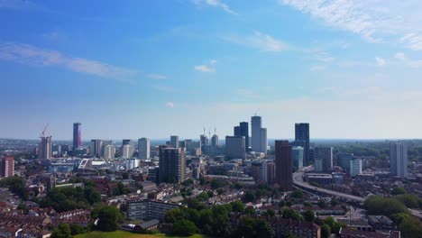 Cinematic-drone-shot-of-South-London-suburb-with-skyscrapers-on-skyline