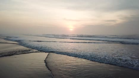 Kippbare-Luftaufnahme-Des-Strandes-Bei-Sonnenuntergang,-Wunderschönem-Himmel-Und-Wellen