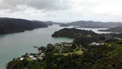 Aerial-wide-shot-of-tiny-village-and-beautiful-fiord-in-Whangaroa,-New-Zealand