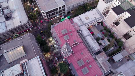 Luftaufnahme,-Die-über-Den-Farbenfrohen-Roten-Glockenturm-Auf-Dem-Dach-Eines-Kommerziellen-Geschäfts-Im-Stadtzentrum-Von-Santiago,-Chile,-Fliegt