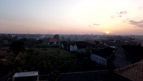 Time-Lapse-Above-Sunset-of-Denpasar-Industrial-Bali-Area-Smoke-Burning-Fields-and-Sun-Going-Down-the-Capital-City