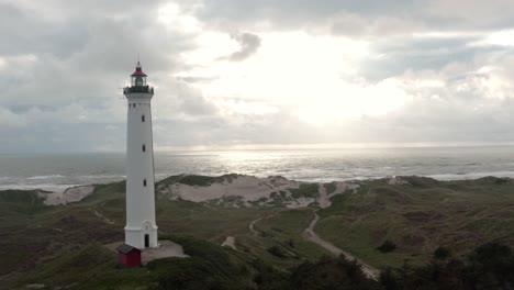 Aerial-footage-of-a-lighthouse-near-the-shore-on-the-western-coast-of-Jutland,-Denmark