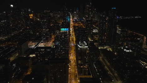 Illuminated-apartment-buildings-in-South-Loop,-nighttime-in-Chicago---Aerial-view