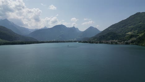 Sailing-boat-on-the-lake-in-Gäsi-Betlis,-Walensee-Glarus,-Weesen-Walenstadt,-Switzerland--drone-view
