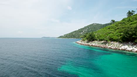 Rocky-Coastal-Line-Near-Glifoneri-Beach,-With-Turquoise-Water-and-Luxuriant-Green-Foliage,-Thassos-Island,-Greece,-Europe