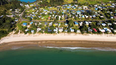 Whangapoura,-small-settlement,-holiday-houses-on-the-beachfront,-New-Zealand---aerial