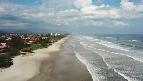 Stunning-ascending-aerial-shot-of-beach-and-ocean,-summertime-Brazil,-Sao-Paolo