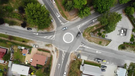 Birdseye-Aerial-View-of-Light-Car-Traffic-on-5-Ways-Roundabout-in-Small-Idyllic-City
