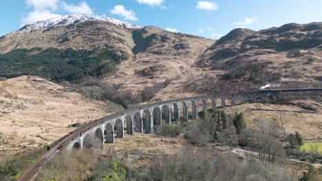 Aerial-Establishing-Shot-of-Jacobite-Steam-Train-at-Glenfinnan-Viaduct-in-Scotland