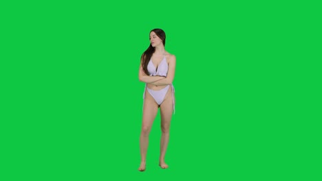Thoughtful-female-model-in-a-bikini-posing-in-front-of-a-green-screen
