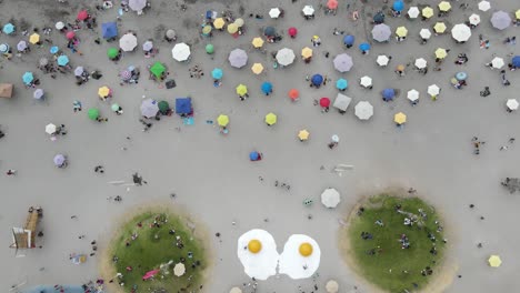 Top-down-drone-aerial-view-of-urban-art-and-people-on-the-pacific-coast-line-during-summer