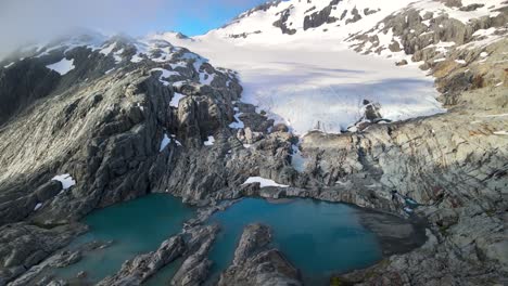 Junge-Frau-Genießt-Nach-Einer-Anspruchsvollen-Wanderung-In-Neuseeland-Einen-Atemberaubenden-Blick-Auf-Den-Vom-Berggipfel-Hängenden-Gletscher---Luftdrohne