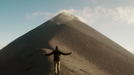 Scenic-Landscape-Of-A-Tourist-Hiker-Running-Towards-The-Ridge-Of-Fuego-Volcano-During-Daytime-In-Guatemala