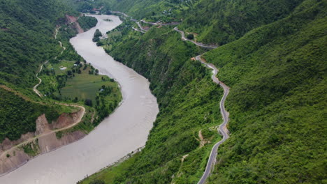 Breathtaking-aerial-view-of-BP-Highway-in-Sindhuli,-Nepal-as-the-drone-captures-the-winding-roads-amidst-lush-green-forests-and-a-meandering-river
