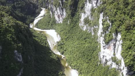 River-in-canyon-surrounded-by-tropical-rainforest---aerial-scenic
