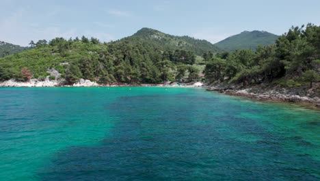 Aerial-Side-View-Of-Glifoneri-Beach,-With-Turquoise-Water-and-Surrounded-By-Luxuriant-Green-Foliage,-Thassos-Island,-Greece,-Europe