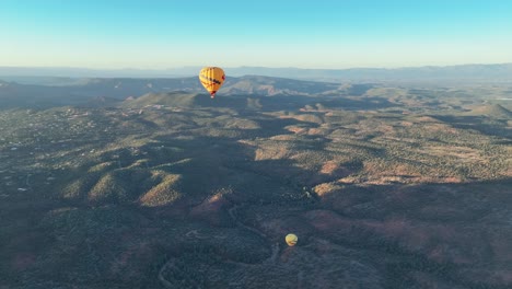 Hot-Air-Balloons-At-Sunrise-In-Sedona,-Arizona,-USA---aerial-drone-shot