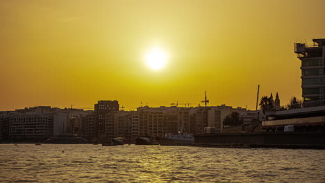 Sliema,-Malt-at-sunset-with-ships-anchored-in-the-Valletta-Harbor---golden-time-lapse