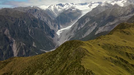 Breathtaking-aerial-reveal-of-Southern-Alps-mountain-scenery-and-Fox-Glacier-in-West-Coast,-New-Zealand