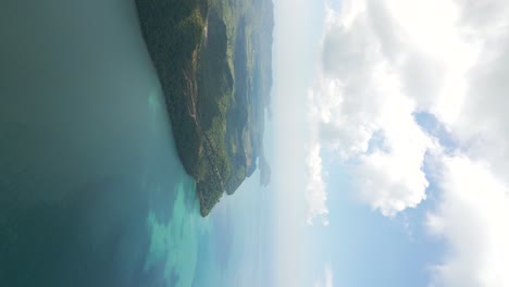 Vertical-drone-view-over-tropical-island-next-to-beautiful-blue-ocean