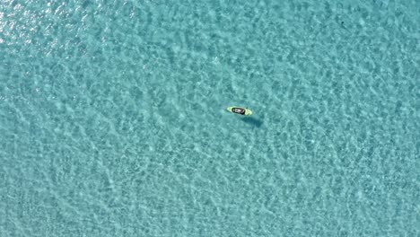 Mid-day-summer-sun-reveals-a-paddle-boarder-gliding-through-the-calm-waters-in-Spain