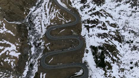 Reveal-drone-footage-of-the-Julier-Pass-in-Switzerland-at-the-end-of-winter-with-patches-of-snow