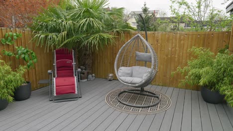 Minimalistic-UK-summer-garden-showing-swing-chair-decking-and-sun-lounger