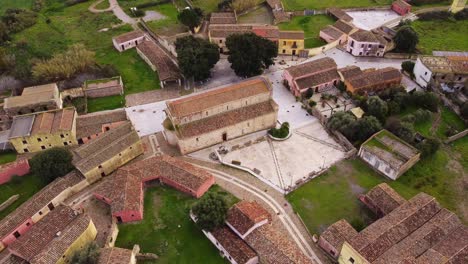 Aerial-of-Tratalias-townscape,-static-drone-view-above-Romanesque-church,-Sardinia