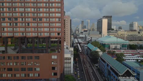 Train-on-Elevated-train-tracks,-station-next-to-hotel