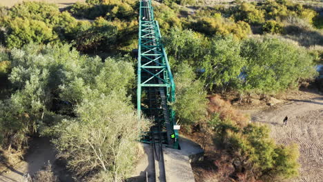 Tourist-spot,-abandoned-railway-bridge-in-Spain,-people-on-train-tracks,-aerial