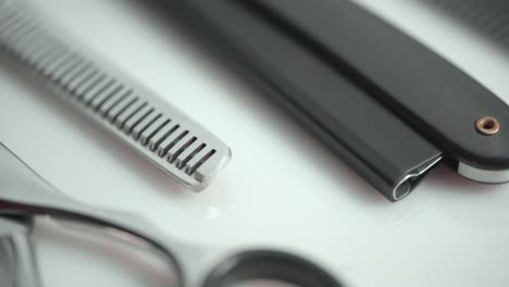 Makroaufnahme-Von-Friseurscheren-Und-Werkzeugen,-Rotierend-Auf-Weißem-Hintergrund