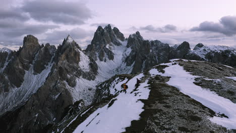 Aerial-view-of-hikers-at-the-Cadini-di-Misurina-viewpoint,-winter-evening-in-Dolomites,-Italy